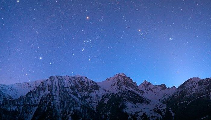 Immagine del cielo stellato sopra montagne innevate
