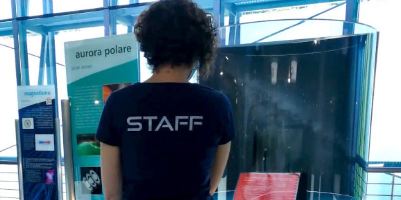 Divulgatore scientifico di spalle con maglia staff